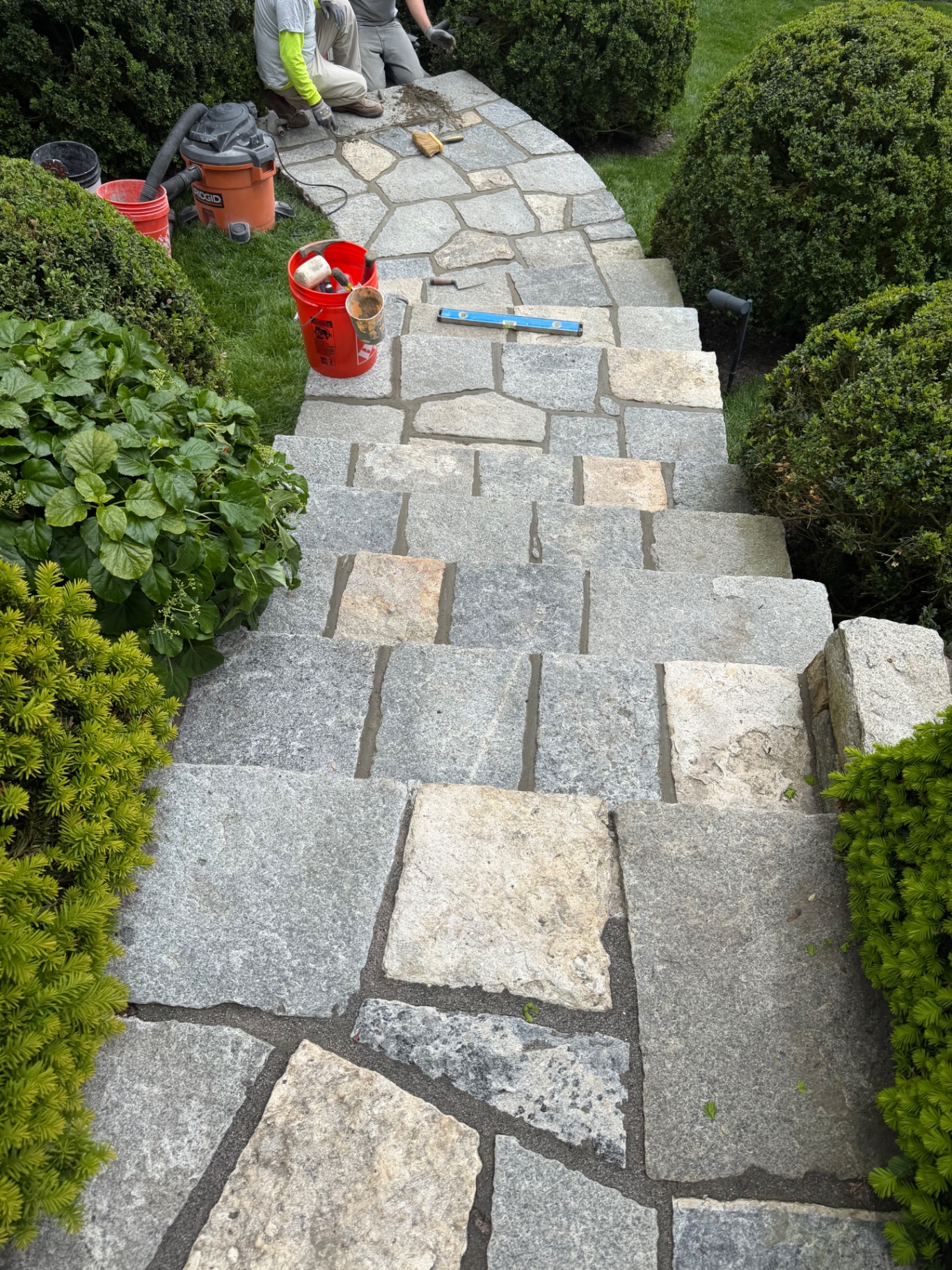Masonry team working on a brick and stone wall construction project
